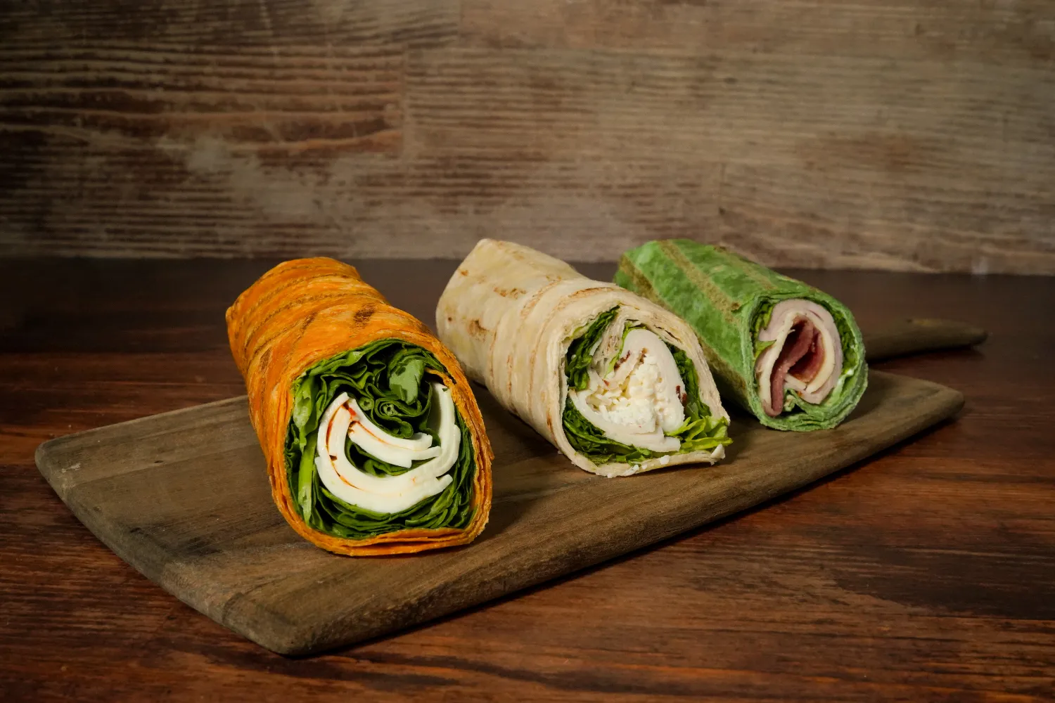Assortment of colorful wraps on a wood tray