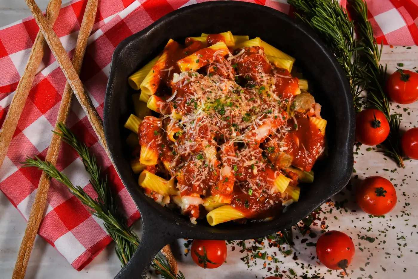 Pasta with red sauce and cheese on the top in a skillet