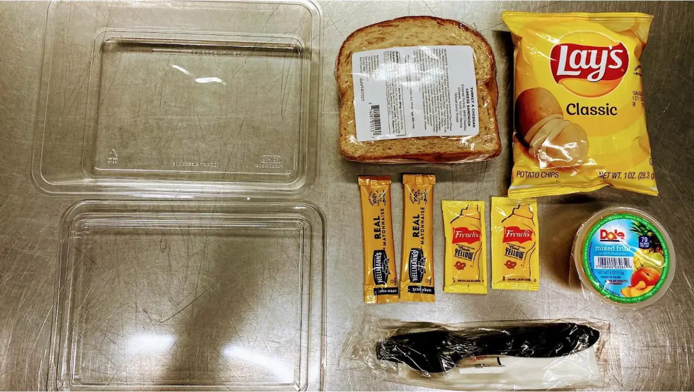 preprepared sandwich box kits with sandwich, chips, fruit cup, chocolate chip cookie, and Hershey chocolate bar